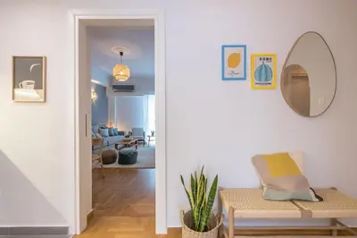 a living room with a chair and a mirror at Zen Palm, Exarchia in Athens
