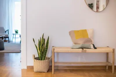 a rattan bench in a living room with a plant at Zen Palm, Exarchia in Athens