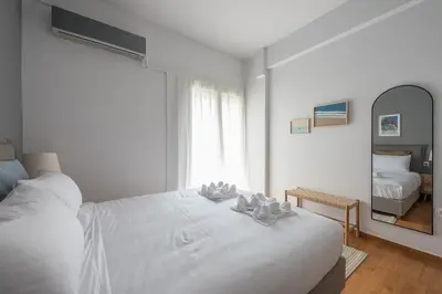 a bedroom with a white bed with two candles on it at Zen Palm, Exarchia in Athens