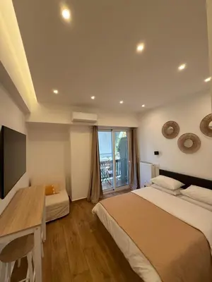 a bedroom with two beds and a desk and a window at Pagrati Cozy Lux Studio-Chremonidou street in Athens