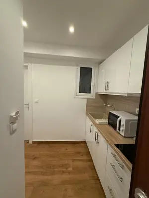 a small kitchen with white cabinets and a microwave at Pagrati Cozy Lux Studio-Chremonidou street in Athens