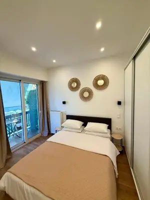 a bedroom with a large bed with two mirrors on the wall at Pagrati Cozy Lux Studio-Chremonidou street in Athens