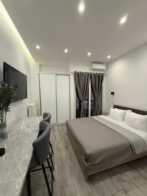a bedroom with a bed and a table in it at Pagrati Luxury Gray Studio-Chremonidou street in Athens