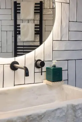 a bathroom sink with a green soap dispenser in front of a mirror at Amazing flat just 500 m from Acropolis museum in Athens
