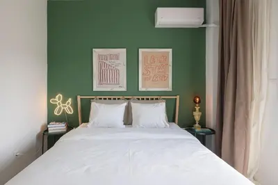a bedroom with a white bed with green walls at Amazing flat just 500 m from Acropolis museum in Athens