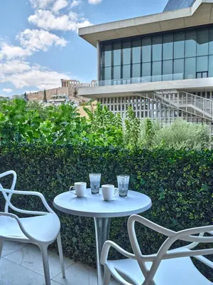 a white table and chairs on a patio with a building at Adorac in Athens