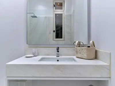 a white bathroom with a sink and a mirror at Adorac in Athens
