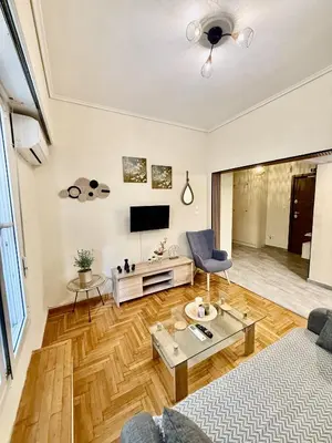 a living room with a couch and a tv at Near Acropolis-Athens in Athens