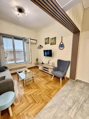 a living room with a couch and a tv at Near Acropolis-Athens in Athens