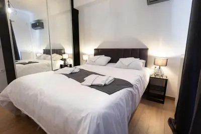 a bedroom with a large white bed with two towels on it at Flouris Apartments in Athens