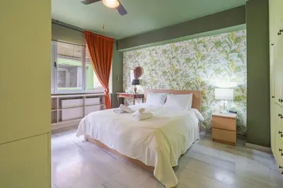 a bedroom with a large bed with a floral wall at Athens' Pearl in Athens