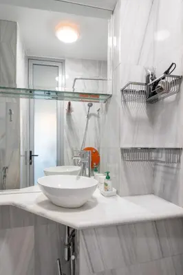a white bathroom with two sinks and a mirror at Athens' Pearl in Athens