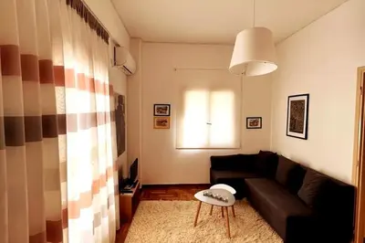a living room with a couch and a table at Quiet apartment in the centre of Athens in Athens