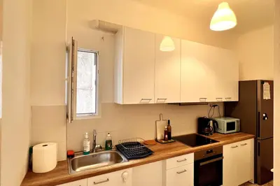 a kitchen with white cabinets and a sink and a microwave at Quiet apartment in the centre of Athens in Athens
