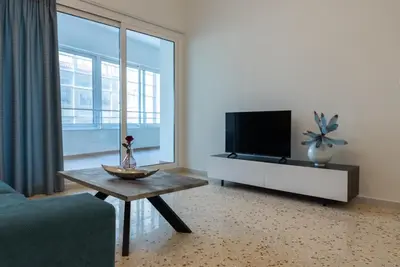 a living room with a tv and a table at Athens at a Glance - Luxury Apartments in Athens