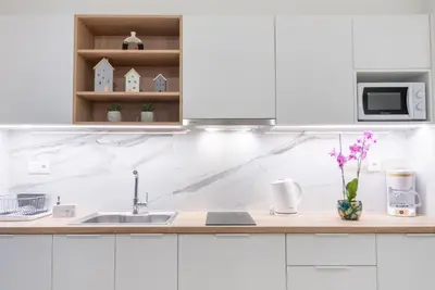 a white kitchen with white cabinets and a sink at Athens at a Glance - Luxury Apartments in Athens
