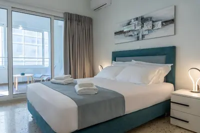 a bedroom with a large bed and a large window at Athens at a Glance - Luxury Apartments in Athens