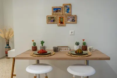 a table with two stools and two plates of fruit at Athens at a Glance - Luxury Apartments in Athens