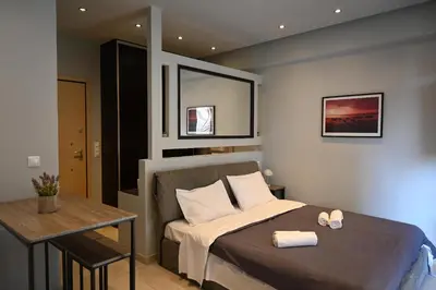 a bedroom with a bed and a table in it at Georgette's Charming Studio near Metro by MPS in Athens