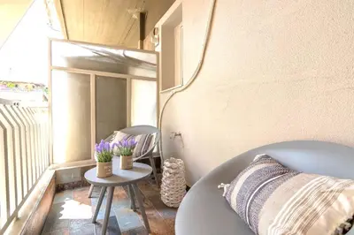 a small balcony with a table and a chair at Georgette's Charming Studio near Metro by MPS in Athens