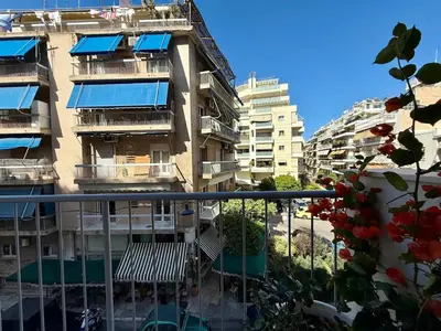 an apartment building with blue awnings and a balcony at Quaint & Central Acropolis apartment in Athens