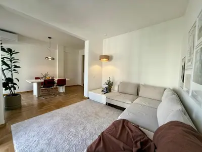 a living room with a white couch and a table at Quaint & Central Acropolis apartment in Athens