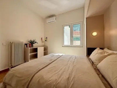 a bedroom with a large bed and a window at Quaint & Central Acropolis apartment in Athens