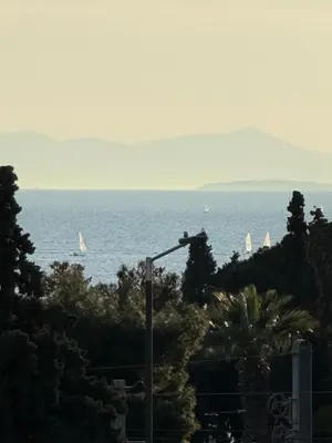 a street light with a view of the ocean with sailboats at Delightful Seaside & Romantic in Athens
