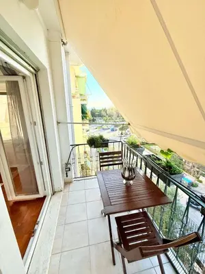 a balcony with a wooden table and chairs at Delightful Seaside & Romantic in Athens
