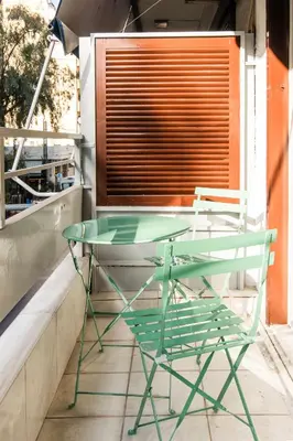 a glass table and two chairs on a balcony at A42 Renovated in 25 8 minutes to Acropolis Museum Heart of Koukaki in Athens
