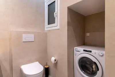 a bathroom with a washing machine and a toilet at A42 Renovated in 25 8 minutes to Acropolis Museum Heart of Koukaki in Athens