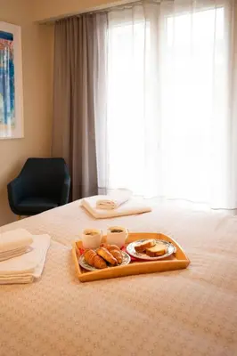 a tray with pastries and two cups on a bed at Acropolis Luxe Stay in Athens