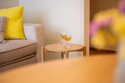 two glasses of wine on a table next to a couch at Acropolis Luxe Stay in Athens