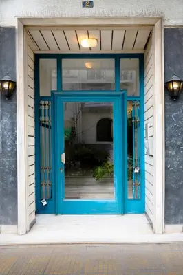 a blue door on a building with a window at Acropolis Luxe Stay in Athens