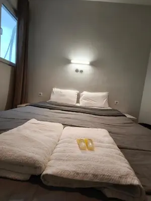 a bedroom with a bed with two towels on it at Liberal Mini Rooms in Athens