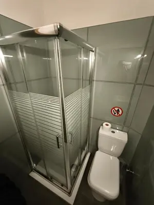 a bathroom with a glass shower and a toilet at Liberal Mini Rooms in Athens