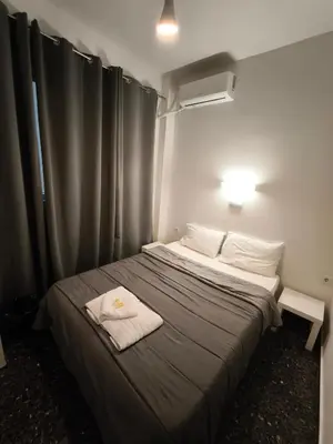 a bedroom with a bed with two towels on it at Liberal Mini Rooms in Athens