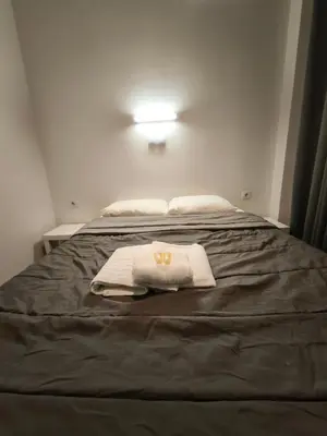 a bed with two towels on top of it at Liberal Mini Rooms in Athens