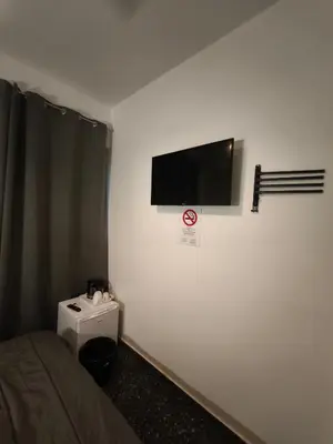 a room with a bed and a flat screen tv on the wall at Liberal Mini Rooms in Athens