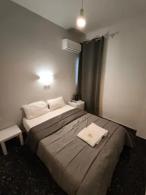 a bedroom with a bed with a towel on it at Liberal Mini Rooms in Athens