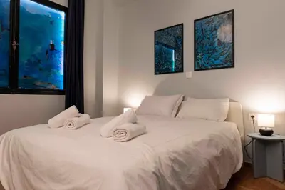 a bedroom with a white bed with towels on it at Modern Blue Retreat in Athens