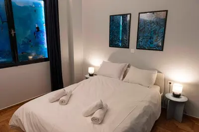 a bedroom with a bed with two towels on it at Modern Blue Retreat in Athens