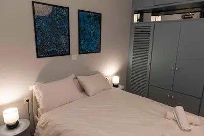 a bedroom with a white bed with two lamps at Modern Blue Retreat in Athens