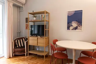 a living room with a tv and a table and chairs at Modern Blue Retreat in Athens