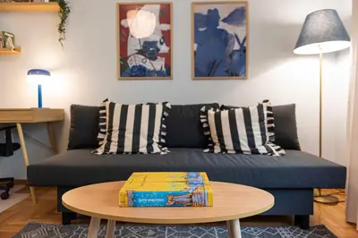 a living room with a couch and a table at Modern Blue Retreat in Athens
