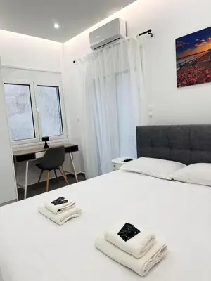 a bedroom with a white bed with two towels on it at Central Apartment At Pangrati in Athens