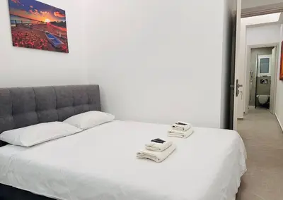 a white bed with two scales on top of it at Central Apartment At Pangrati in Athens