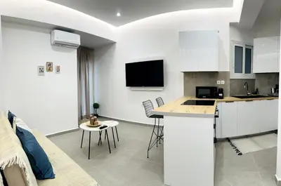 a kitchen with white cabinets and a counter top at Central Apartment At Pangrati in Athens