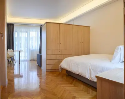 a bedroom with a bed and a wooden cabinet at Athens Luxury Apartments Rodos in Athens