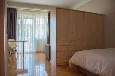 a bedroom with a bed and a desk and a window at Athens Luxury Apartments Rodos in Athens